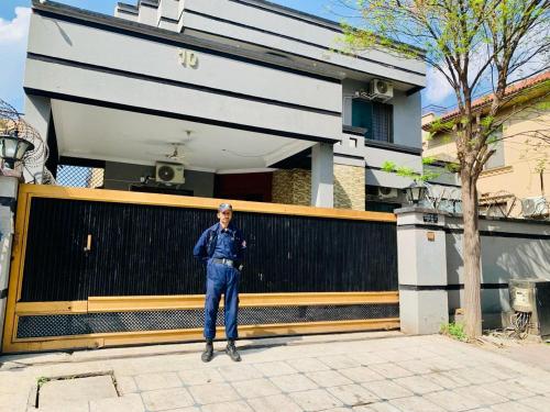 a man standing in front of a house at Hayat Grand Guest House in Islamabad
