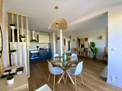 a dining room and living room with a table and chairs at Appartement proche plage, CARNON in Mauguio