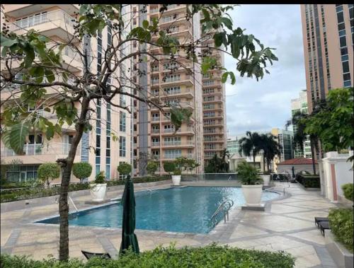 ein Schwimmbad in einer Stadt mit hohen Gebäuden in der Unterkunft Cozy Home at Venice Luxury BGC in Manila