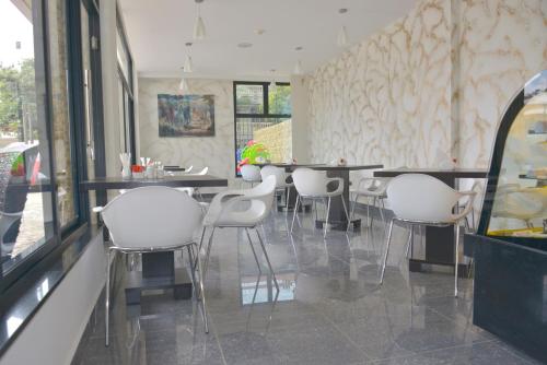 a dining room with white chairs and a table at La Maison Royale in Nairobi