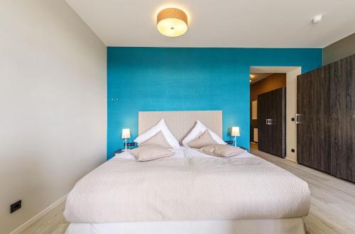 a bedroom with a large white bed with blue walls at Alte Seefahrtschule App 33 "Oberdeck" in Wustrow