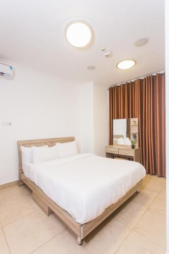 a bedroom with a large bed with white sheets at Accra Luxury Apartments at Avant Garde in Accra