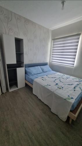 a bedroom with a bed and a window at Joms Cozy Staycation in Calamba