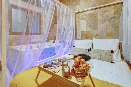Un dormitorio con una cama y una mesa con comida encima. en L'ÉVASION I BED&SPA I Jacuzzi I Cozy I HyperCentre I RENT IMMO, en Dijon