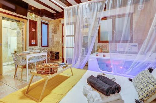 sala de estar con mesa y habitación con bañera en L'ÉVASION I BED&SPA I Jacuzzi I Cozy I HyperCentre I RENT IMMO, en Dijon