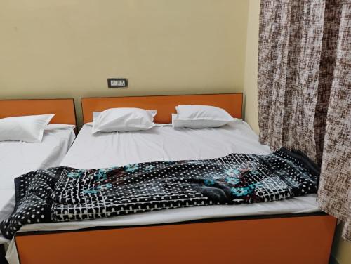 a bed with a blanket on top of it at Geeta Teerth Guest House AC and Non AC Rooms in Ayodhya