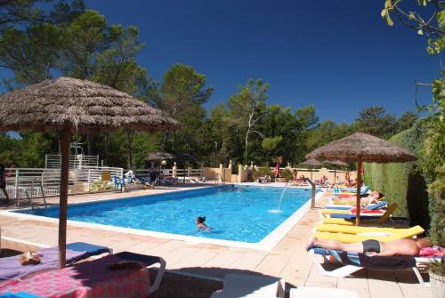 - une piscine avec des chaises et des parasols dans l'établissement Camping Le Parc, à Saint-Paul-en-Forêt
