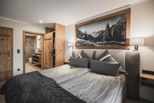 a bedroom with a bed with a picture on the wall at BERGSUCHT-Ruhpolding, Traumlage am sonnigen Südhang, kostenlose Parkplätze, schnelles WLAN, ruhige Sackgasse, NETFLIX inklusive in Ruhpolding