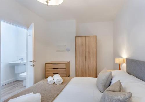 阿尔弗斯顿Lonsdale House Boutique Apartments的一间卧室，床上有两条白毛巾