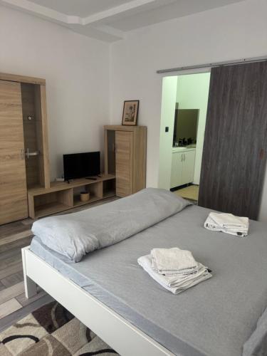 a bedroom with a bed with two towels on it at Compact House in Cluj-Napoca