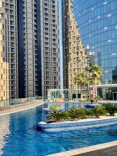 a large swimming pool in a city with tall buildings at Sea Breeze 1BR in Luxury Complex with Sea View Pools Gym on Reem Island in Abu Dhabi