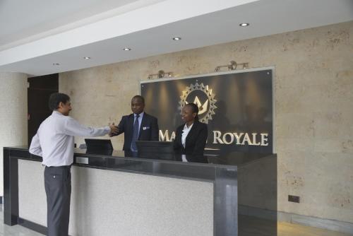 a man shaking another mans hand at a reception desk at La Maison Royale in Nairobi