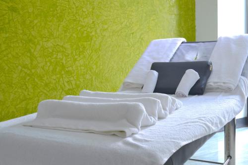 a white couch with white towels on it with a green wall at La Maison Royale in Nairobi