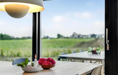 a table with a candle and pink flowers on it at 3 Bedroom Beautiful Home In Haderslev in Haderslev