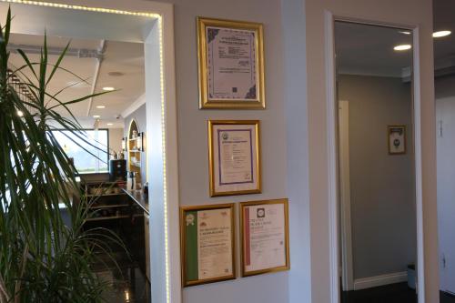 a hallway with framed pictures on a wall at Şahin Tepesi Suite Otel in Trabzon