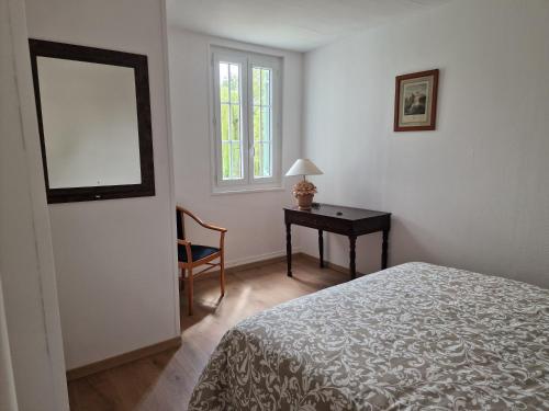 une chambre avec un lit, une table et un miroir dans l'établissement domaine de La vie, à Sainte-Marguerite-de-Viette