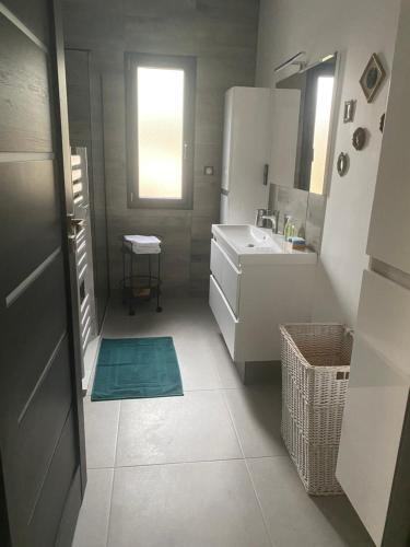 a small white kitchen with a sink and a mirror at Maison paisible proche du centre in Besançon