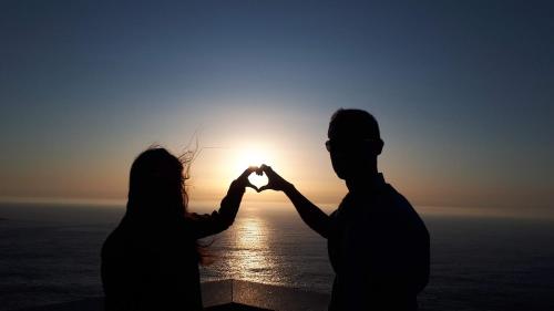 a man and a woman making a heart with their hands at Paraíso Ortegal in Feás