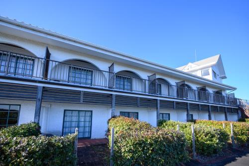 a white building with windows and a fence at Kashikojima Hotel Bay Garden in Shima