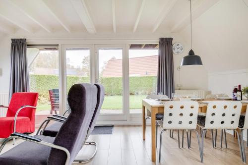 a dining room with a table and chairs at Gele Kwikstaart I Ruime Woning met Omliggende Tuin in Zwiggelte