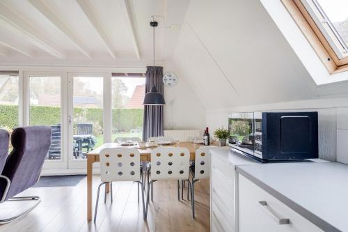 a kitchen and dining room with a table and chairs at Gele Kwikstaart I Ruime Woning met Omliggende Tuin in Zwiggelte