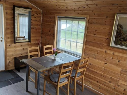 a dining room in a log cabin with a table and chairs at Hardangerfjord panorama 1 in Kvam