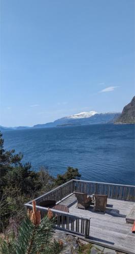 a wooden deck with benches and a view of the ocean at Hardangerfjord panorama 1 in Kvam
