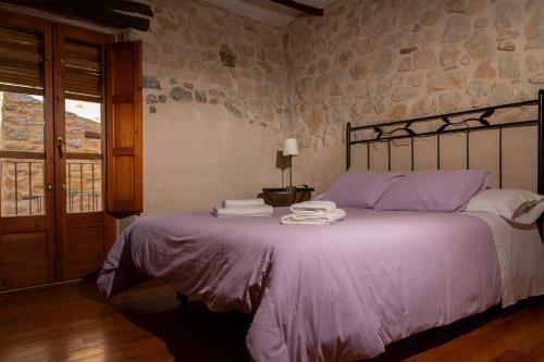 a bedroom with a large bed with purple sheets at Casa Alta in Valderrobres