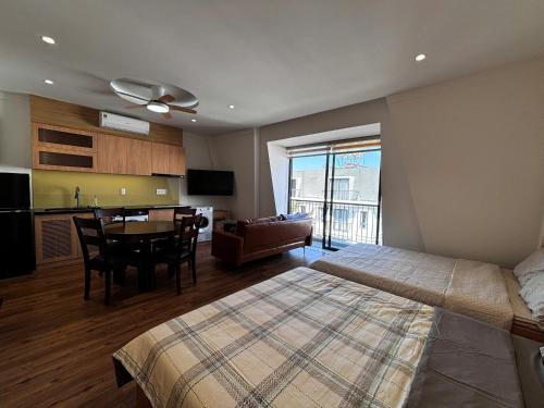 a bedroom with a bed and a kitchen with a table at Wabi Homes in Buon Ma Thuot