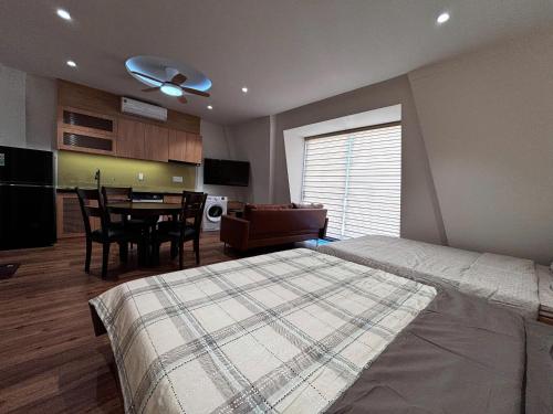 a bedroom with a bed and a table and a kitchen at Wabi Homes in Buon Ma Thuot