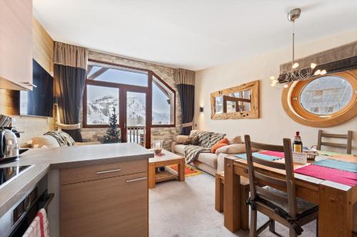 a kitchen and living room with a table and a couch at Chalet Neva - luxury chalet with sauna by Avoriaz Chalets in Avoriaz