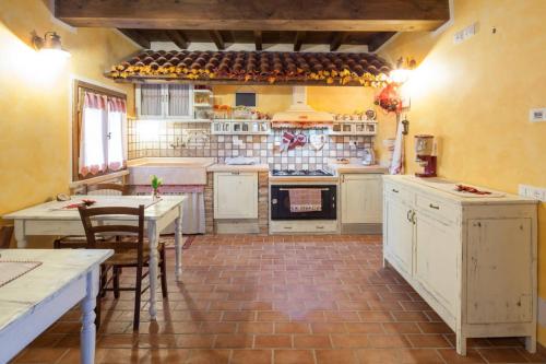 a kitchen with white cabinets and a table and chairs at La Casa Delle Rondini in Roncoferraro