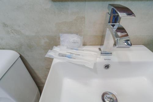 a bathroom sink with a faucet and toothbrushes on it at Bellevue Chalets by Pushella in Nuwara Eliya