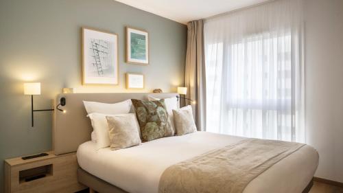 a bedroom with a large bed with a window at Residhome Quai d’Ivry in Ivry-sur-Seine