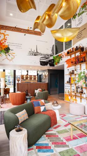 a living room with a green couch and a colorful rug at Residhome Quai d’Ivry in Ivry-sur-Seine