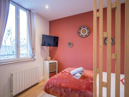 ein Schlafzimmer mit einem Bett und einem Fernseher an der Wand in der Unterkunft Le Cosy Express in Villefranche-sur-Saône
