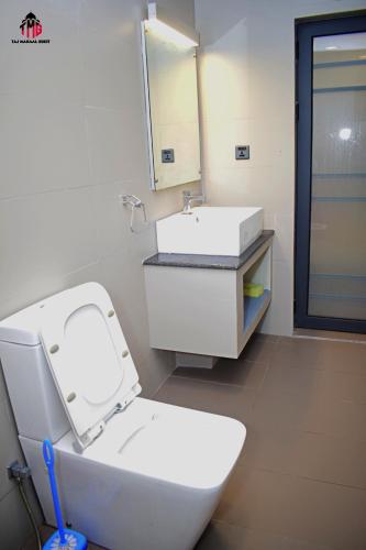 a bathroom with a white toilet and a sink at Taj Mahaal Guest in Colombo