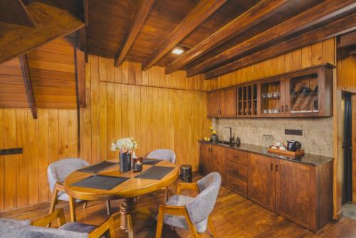 a kitchen with a table and chairs in a room at Bellevue Chalets by Pushella in Nuwara Eliya