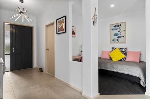 a bedroom with a bed in the corner of a room at A Beach Hive at Papamoa Beach - 4 bedrooms in Papamoa