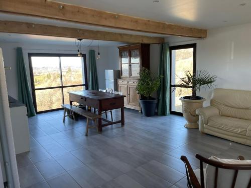 un salon avec une table et un canapé dans l'établissement La loge des ânes, à Naucelles