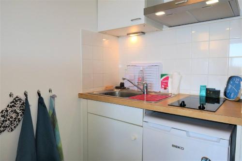 une petite cuisine avec un évier et un comptoir dans l'établissement Bel appartement rénové avec jardin, VUE MER à PERROS-GUIREC - Réf 946, à Perros-Guirec