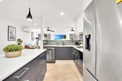 a kitchen with gray cabinets and a white counter top at The Residence- Rainforest Retreat in Stratford