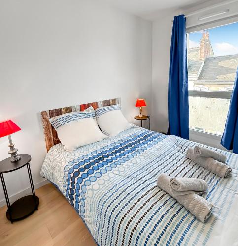 - une chambre avec un lit doté de rideaux bleus et d'une fenêtre dans l'établissement Balcon privé & déco élégante, au Mans