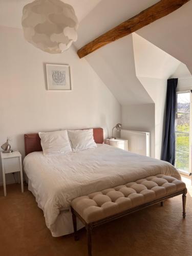 une chambre avec un grand lit et une fenêtre dans l'établissement Grande maison de familles à Sancerre, à Feux