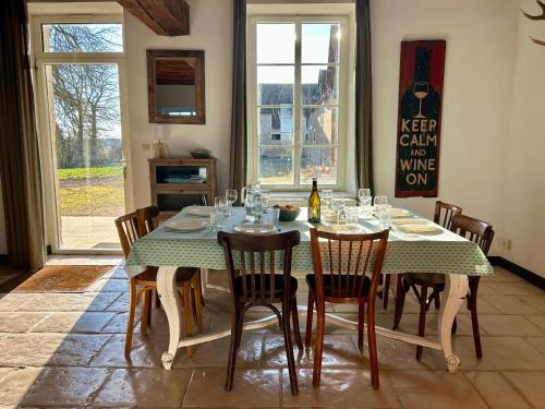 une salle à manger avec une table avec des chaises et une bouteille de vin dans l'établissement Grande maison de familles à Sancerre, à Feux