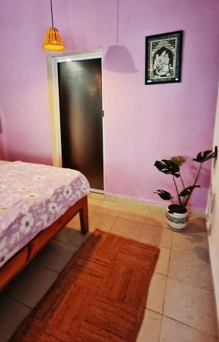 a bedroom with a bed and a potted plant at Secret Hill in Canacona