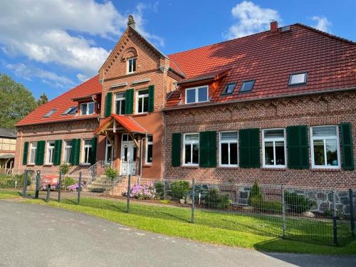 una gran casa de ladrillo con techo rojo en Das Landhaus Wohnung 2, en Kirch Mulsow