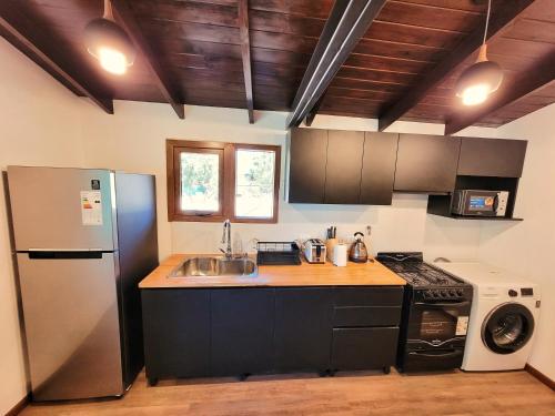 eine Küche mit Spüle und Kühlschrank in der Unterkunft Casa en San Carlos de Bariloche in San Carlos de Bariloche