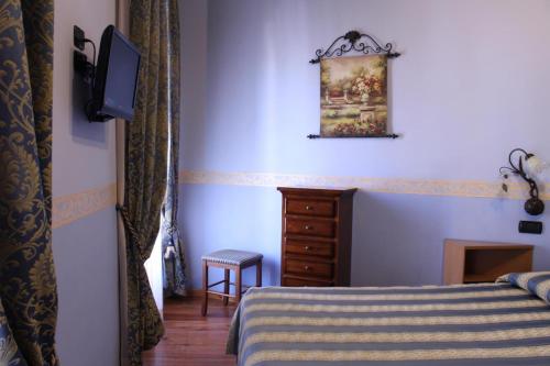 a bedroom with a bed and a dresser and a television at Hotel Belle Epoque in Sanremo