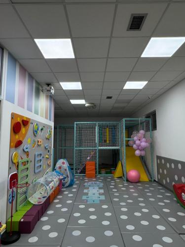 a room with a playroom with a slide and a climbing wall at Bed & Coffee LUKAS Krusevac in Kruševac